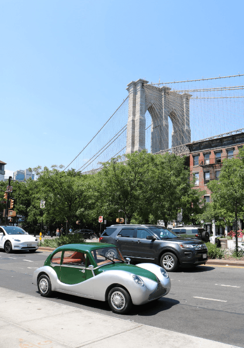 Model O1 on a Brooklyn street with the Brooklyn Bridge behind it